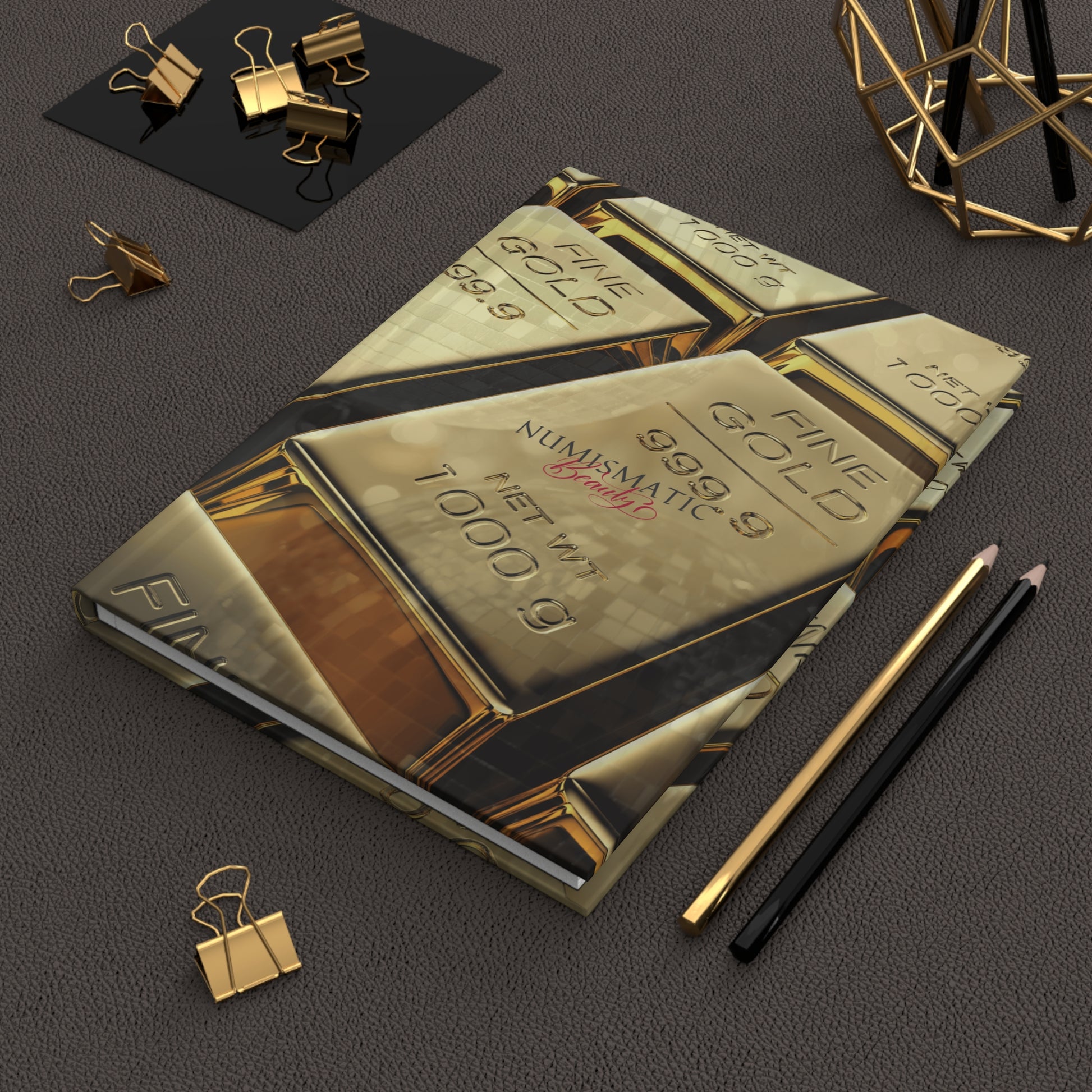 Gold Bar Journal by Numismatic Beauty, shown on a table with pencils. Features a matte cover and designed for gold investors and collectors.